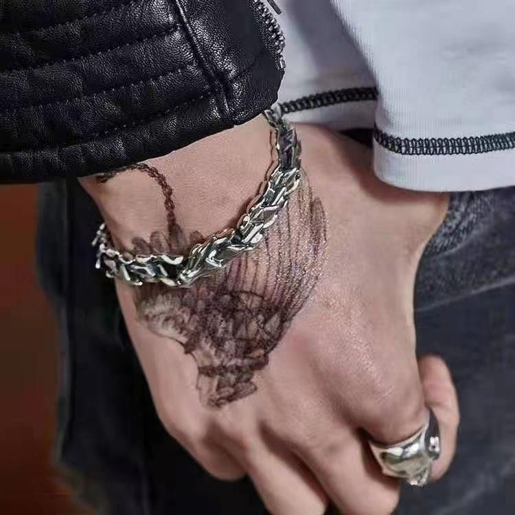 man wearing dragon titanium bracelet wrist side view taoist kaiguang amulet men protection evil ward dark background