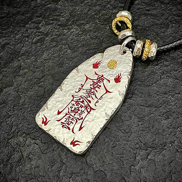Macro shot of the supreme evil-banishing symbols on the back of the hammered silver pendant.