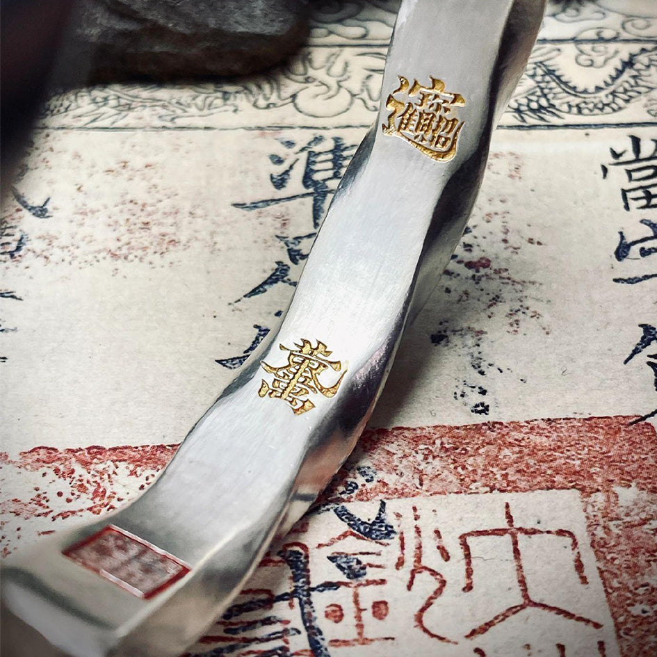 Close-up of the gold-inscribed Wealth Attraction Mantra inside the bracelet, symbolizing abundance and high-frequency fortune.