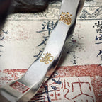 Close-up of the gold-inscribed Wealth Attraction Mantra inside the bracelet, symbolizing abundance and high-frequency fortune.