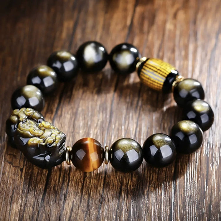  Gold obsidian Pixiu wealth bracelet with tiger eye bead and yellow stripe barrel on rustic wooden surface
