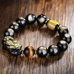  Gold obsidian Pixiu wealth bracelet with tiger eye bead and yellow stripe barrel on rustic wooden surface