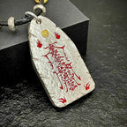 Detailed view of the rugged hammered texture and sacred cinnabar engraving on the TAIJIAURA protection talisman.