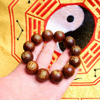 Hand wearing Taoist Five Thunder Command bracelet made of consecrated thunderstruck jujube wood for spiritual protection.