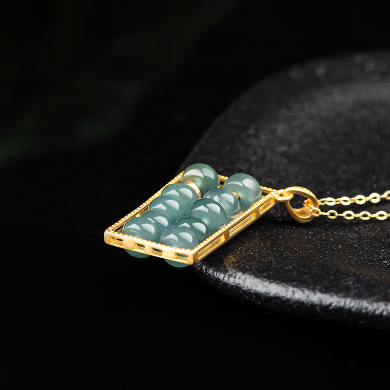 jade abacus pendant close up gold frame natural green jade taoist kaiguang wealth accumulation