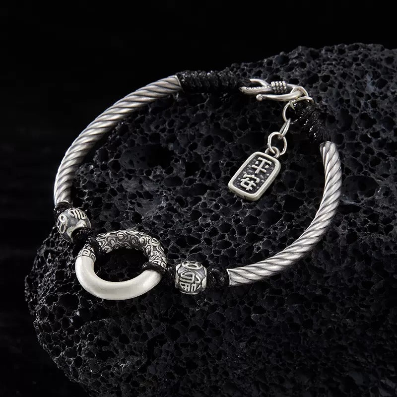 Taoist KaiGuang jade peace buckle protection bracelet — evil warding amulet on natural stone display