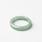  Jadeite KaiGuang ring lying flat on white background top view showing even light green color and smooth polished band