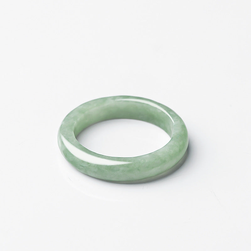  Jadeite KaiGuang ring lying flat on white background top view showing even light green color and smooth polished band