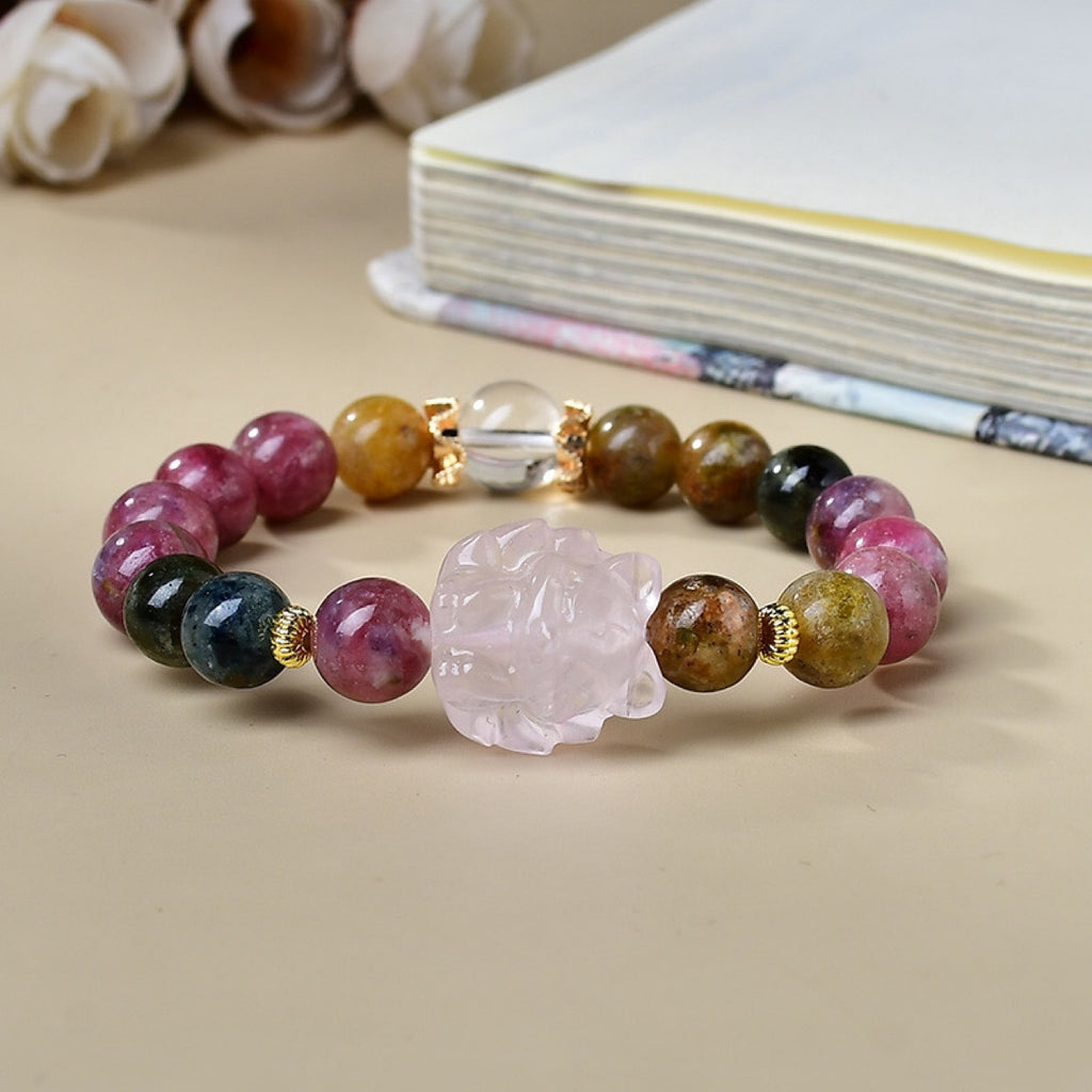 Rainbow tourmaline love attraction crystal bracelet with rose quartz nine-tail fox carving clear quartz ball gold crown spacers on cream background book Taoist KaiGuang