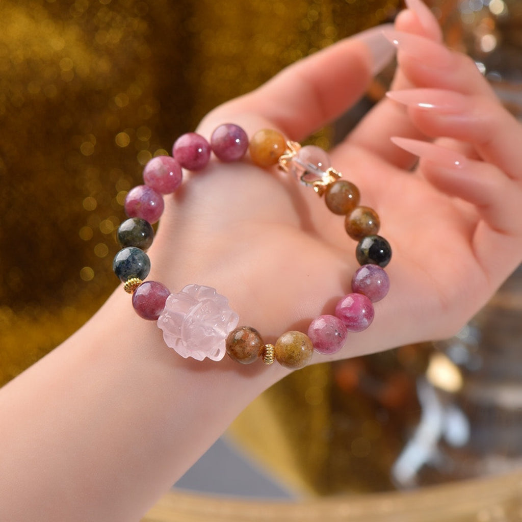 Woman hand holding rainbow tourmaline and rose quartz nine-tail fox love attraction crystal bracelet gold glitter background Taoist KaiGuang charm healing confidence