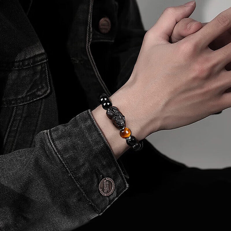 Man wearing gold obsidian Pixiu KaiGuang wealth attraction bracelet with tiger eye on wrist lifestyle