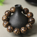 Men's luxury tiger stripe agarwood bracelet 18mm large beads on black vase prop showing gold brown tiger stripe patterns Taoist KaiGuang wealth meditation stress relief