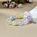 Natural milky quartz bracelet 14mm beads with aquamarine citrine amethyst and clear quartz cube silver spacers side view on beige background with white roses crystal healing cleansing