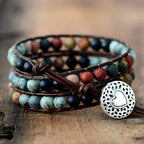 Mixed matte gemstone triple wrap bracelet with multicolor natural stone beads on rock surface