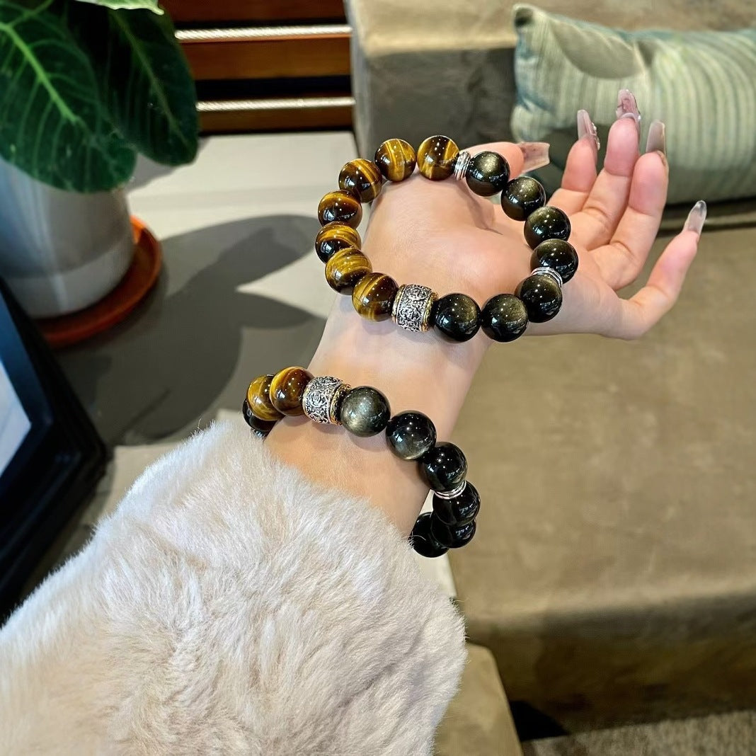 Two obsidian tiger eye protection strength bracelets different sizes woman hand display indoor natural light green plant background silver engraved spacer KaiGuang
