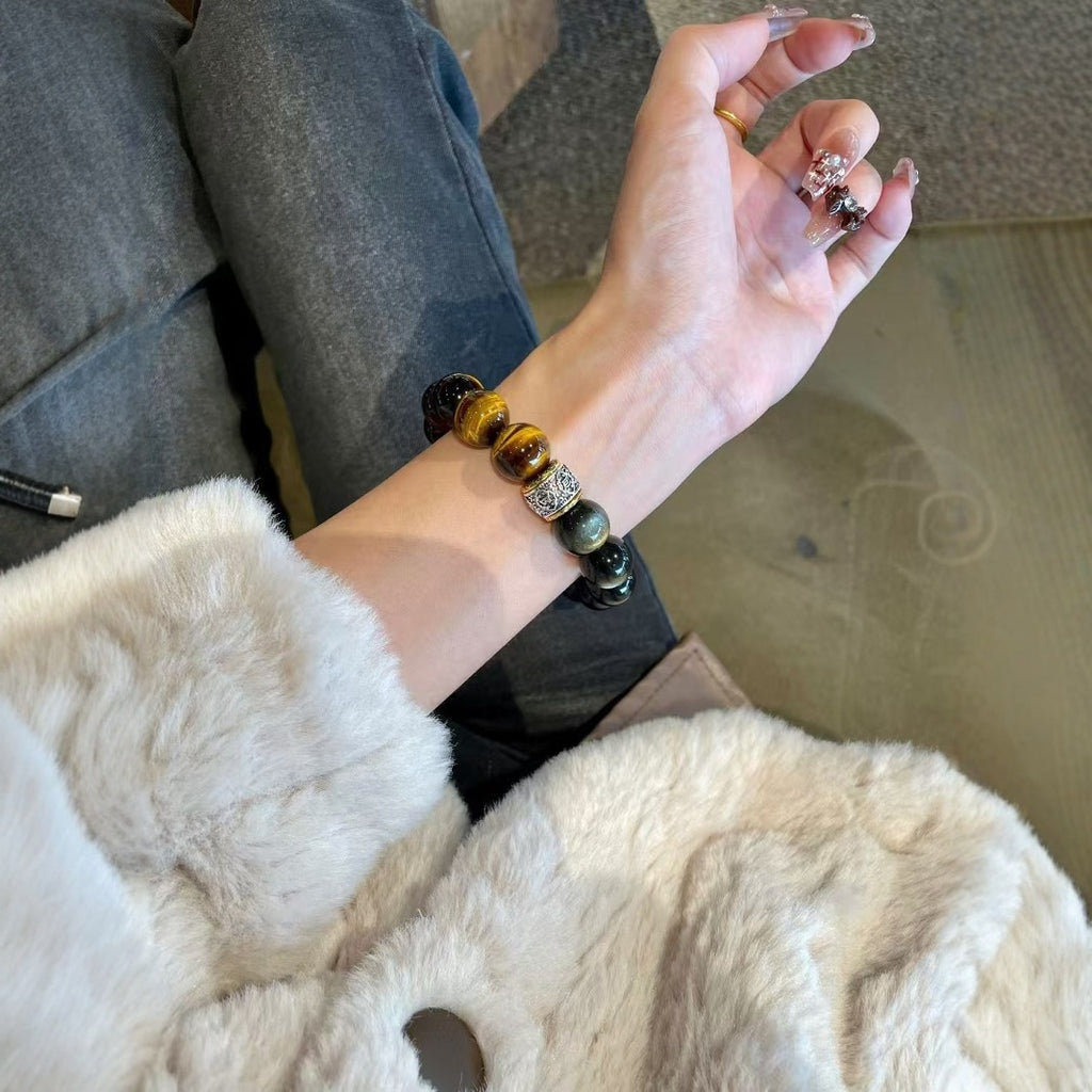 Woman wearing obsidian tiger eye protection strength bracelet casual lifestyle white fluffy coat denim jeans silver spacer bead natural crystal jewelry