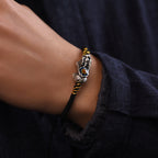 Man wearing black cord Pi Xiu KaiGuang bracelet on wrist with silver beast and blue enamel detail