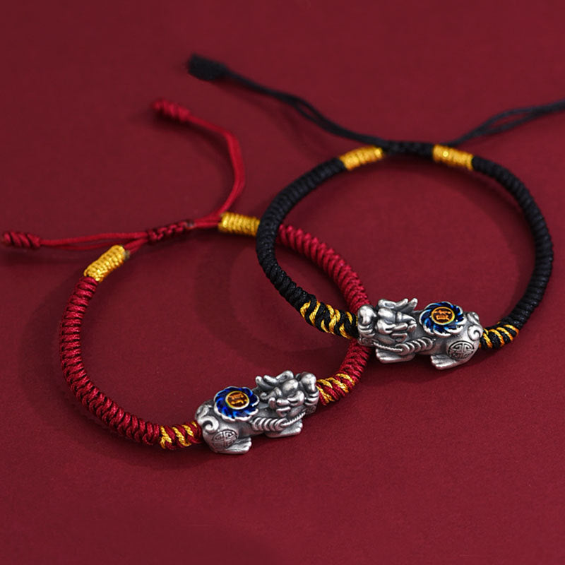  Red and black cord Pi Xiu bracelets side by side on red background showing silver wealth guardian charm