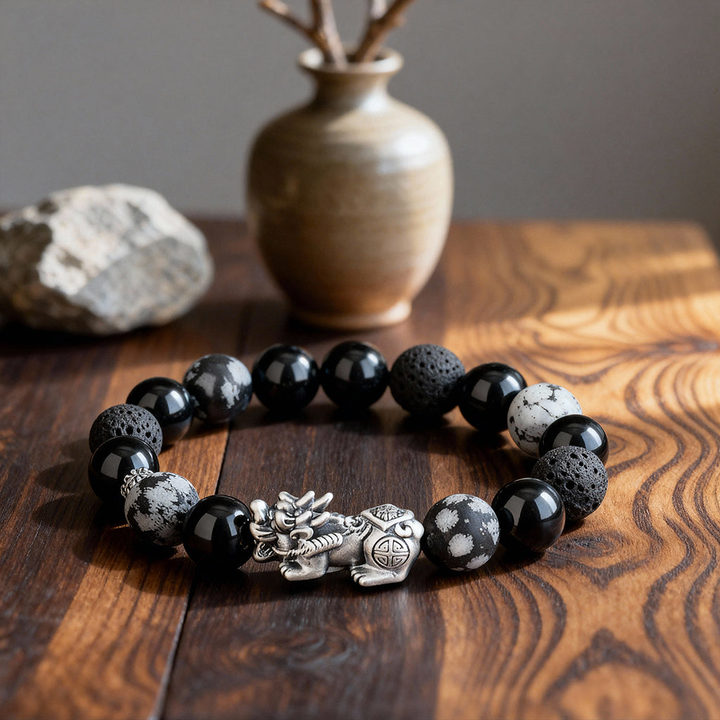 Pixiu obsidian volcanic stone Taoist KaiGuang wealth bracelet flat lay on dark wood surface with ceramic vase zen background