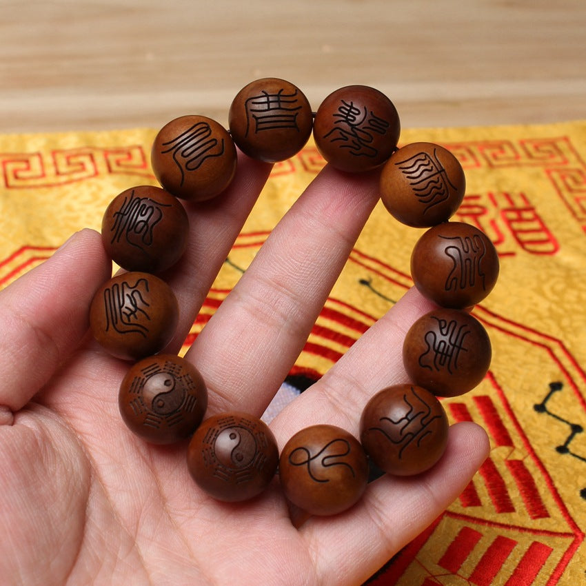 A human hand firmly holds the massive 2.0cm thunderstruck wood bracelet, showing the large scale of the beads for powerful evil exorcism and spiritual authority.