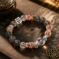 Natural black rutilated quartz and strawberry quartz protection grounding bracelet silver spacers clear quartz cube on Taoist yin yang plate dark gold background KaiGuang
