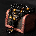 Rainbow eye obsidian 108 bead bracelet coiled on wooden jewelry box black gold meditation jewelry