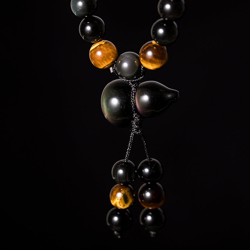 Rainbow eye obsidian 108 bead bracelet showing gourd shaped obsidian pendant and tassel on black background