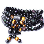 Rainbow eye obsidian 108 bead Taoist KaiGuang bracelet on white background showing engraved pendant and tassel detail