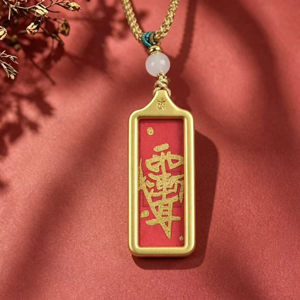 Front view of a red Taoist talisman pendant with gold-colored markings and frame on a red background.