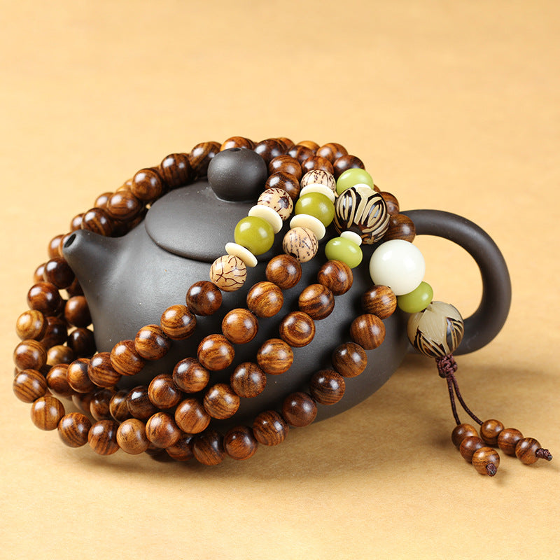 Rosewood 108 bead meditation mala four wrap bracelet with green jade turquoise bodhi seed accents draped over black zisha clay teapot warm beige background Taoist KaiGuang zen grounding meditation