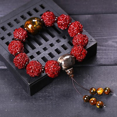 Nepal Rudraksha evil ward bracelet with silver charm and tigers eye tassel beads on dark wood display Taoist KaiGuang protection spiritual bracelet