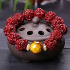  Nepal Rudraksha protection bracelet with golden tigers eye accent bead resting on purple clay incense burner Taoist KaiGuang evil ward jewelry
