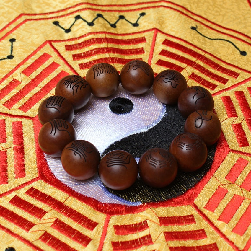 A close-up side view of a single 2.0cm aged thunderstruck wood bead with gold-painted Ten Character scripture, resting on a dark display stand for disaster relief.