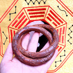 The Supreme Yin-Yang Ring resting on a rustic wood surface, acting as a functional energy shield that creates an unbroken loop of pure yang energy.