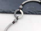 Close-up of white jade peace buckle ring carved silver cloud pattern surround engraved silver beads on silver twisted rope brown braided cord slate background Taoist KaiGuang protection evil warding amulet detail

