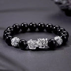 Natural obsidian stone Pixiu money bracelet resting on dark rock silver guardian beads Longhu Mountain KaiGuang consecrated