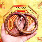 A professional Taoist Yin-Yang Ring held in hand, showing the seamless one-piece thunderstruck wood carving and sacred talisman commands for absolute defense.