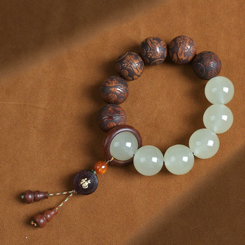 Tai chi yin yang meditation bracelet white quartz and carved tea wood beads overhead view on warm leather background Taoist KaiGuang talisman