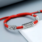Taiji aura bracelet red braided cord with sterling silver dual Pixiu wealth guardian and lock bead closeup on white background Taoist KaiGuang