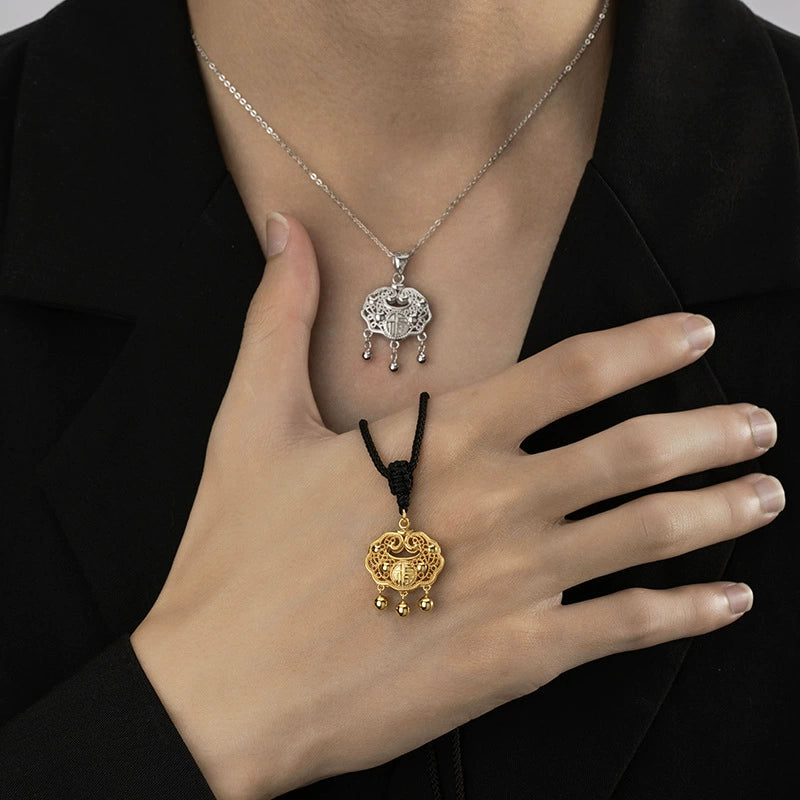 Woman wearing both gold braided cord and silver chain taiji aura peace lock pendants on chest over black blazer showing eastern guardian talisman Taoist KaiGuang protection jewelry two styles