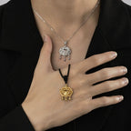 Woman wearing both gold braided cord and silver chain taiji aura peace lock pendants on chest over black blazer showing eastern guardian talisman Taoist KaiGuang protection jewelry two styles