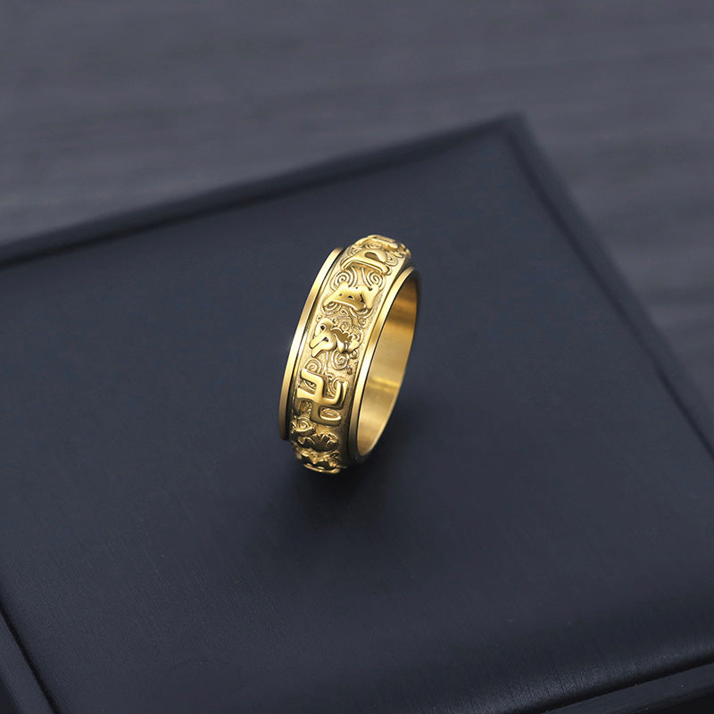 Single gold Taoist KaiGuang spinner ring on dark background showing engraved rune pattern
