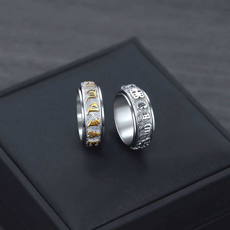 Silver Taoist KaiGuang spinner ring placed on natural stone showing wealth attraction rune detail
