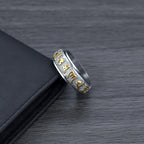 Close up of silver Taoist KaiGuang spinner ring showing rune engravings on dark background