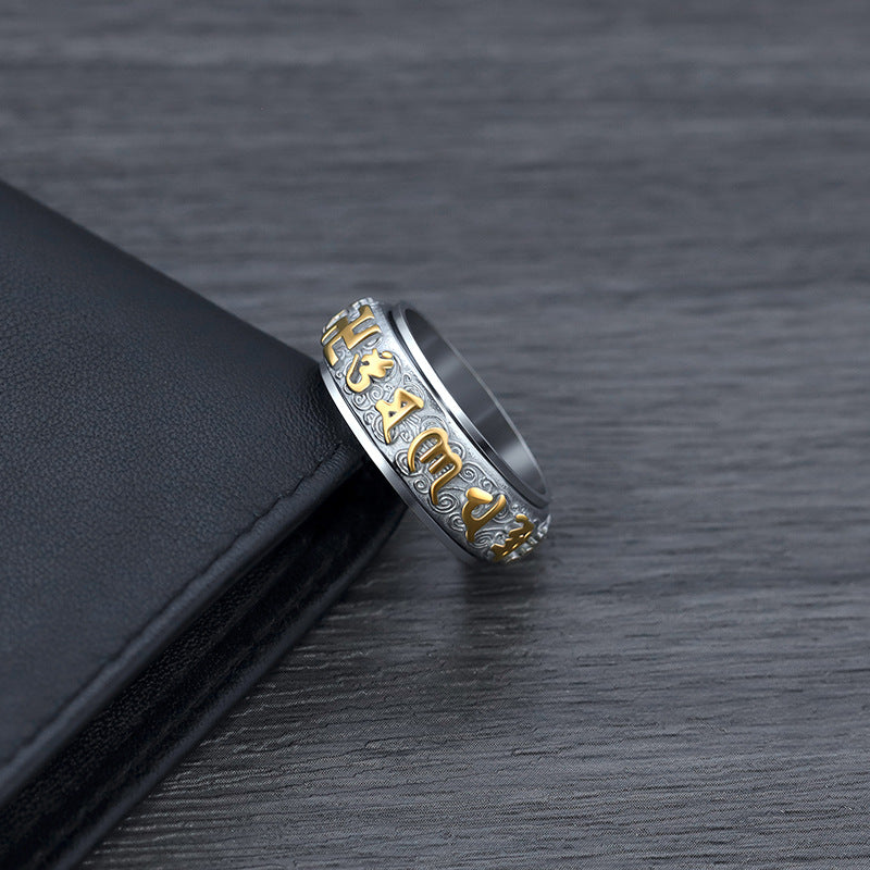 Close up of silver Taoist KaiGuang spinner ring showing rune engravings on dark background