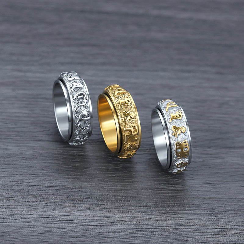  Gold and silver Taoist rune spinner rings flat lay on dark background showing engraved details