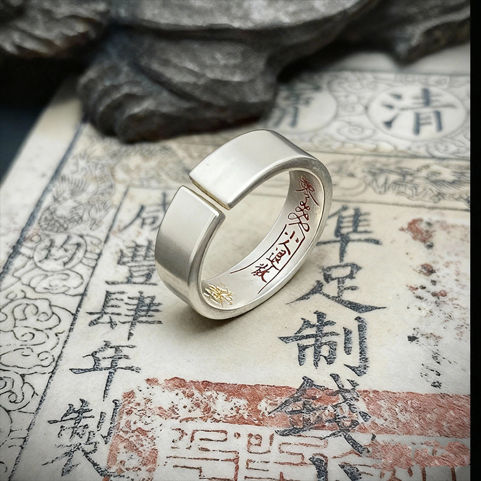 Macro view of the four supreme Taoist talismans precision-engraved inside the silver band.