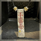 A vertical close-up of the protection talisman, highlighting the sacred cinnabar activation and the power of its core defense.