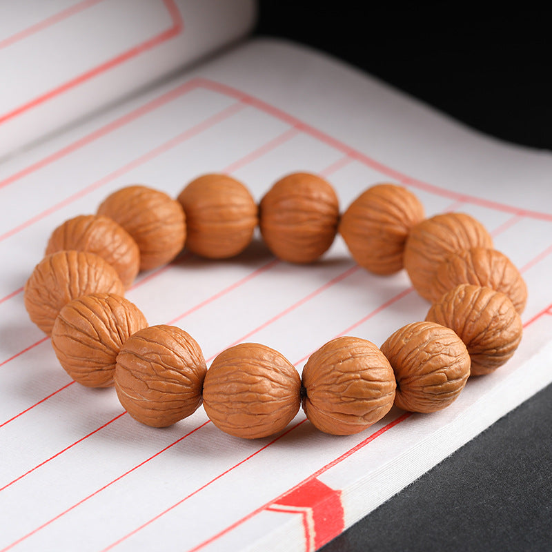 Close-up of natural wild walnut bracelet beads showing original skin grain texture on white background Taoist KaiGuang wealth attraction grounding energy