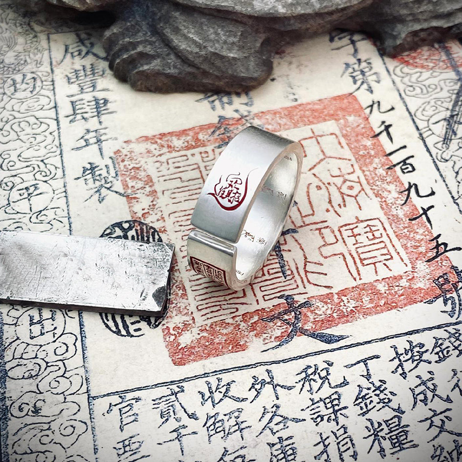 close-up of wealth ring engraved with “zhao cai jin bao” symbol for attracting prosperity and abundance
